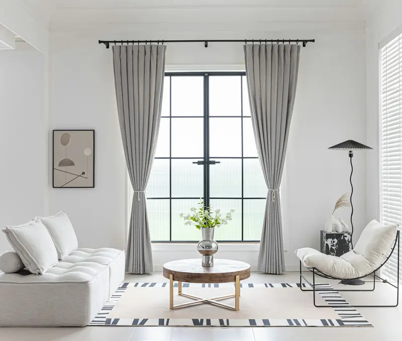 Grey curtains framing white sheers in a bright living room