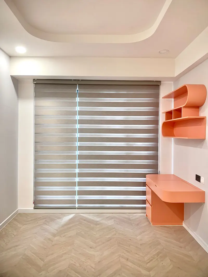 Grey zebra blinds with alternating sheer and solid bands across a study window